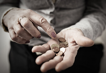 Older person counting coins in her palm