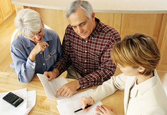 Mature couple talking to financial planner at home