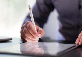 Image of person writing on tablet.