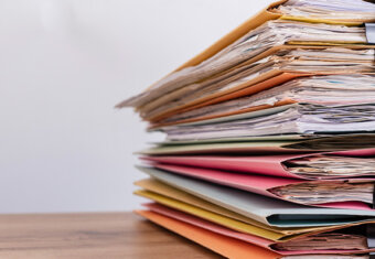 Photo of folders on desk with papers inside.