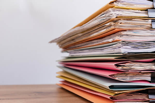Photo of folders on desk with papers inside.